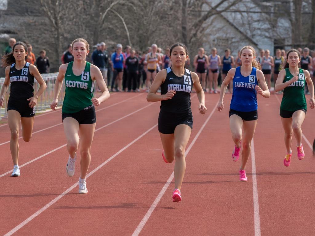 Middle school girls track athletes sprinting on the track